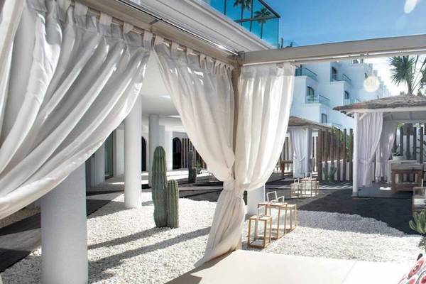 Außenbereich des Guayarmina Princess Hotels mit weißen Vorhängen und weichen Kissen.