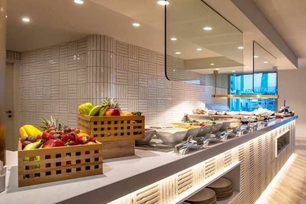 Frühstücksbuffet im Guayarmina Princess Hotel mit Obst, Tellern und Tischen.