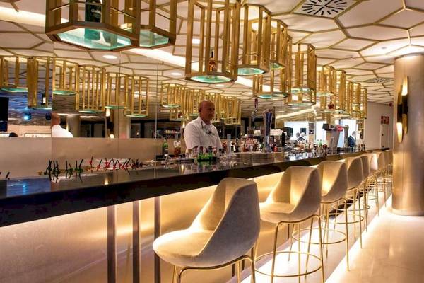 Innenansicht der Bar im Guayarmina Princess Hotel mit goldenen Kronleuchtern und modernen Stühlen.