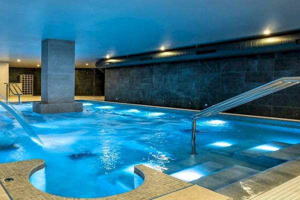 Innenpool des Guayarmina Princess Hotels mit blauem Wasser und beleuchteten Stufen.