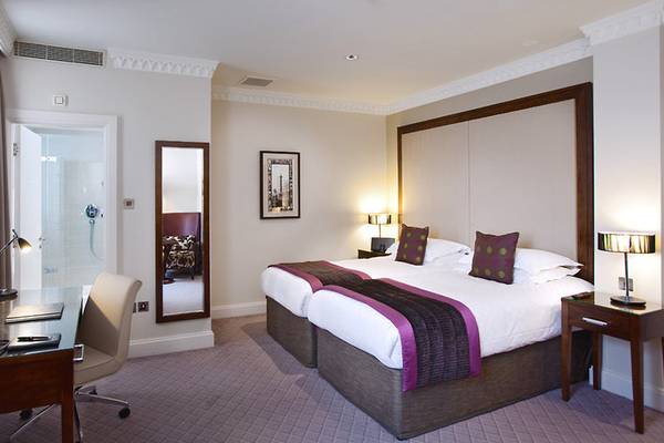 Schlafzimmer im Clermont Hotel, Charing Cross mit zwei Betten, Schreibtisch und Stuhl.