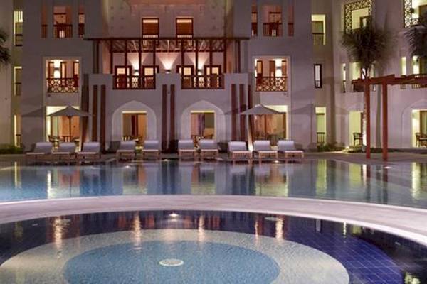 Poolbereich des Sifawy Boutique Hotels mit Loungeliegen und beleuchteten Gebäuden