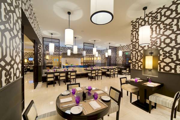 Innenansicht des Restaurants des Sifawy Boutique Hotels mit runden Tischen und geometrischen Wandmustern.