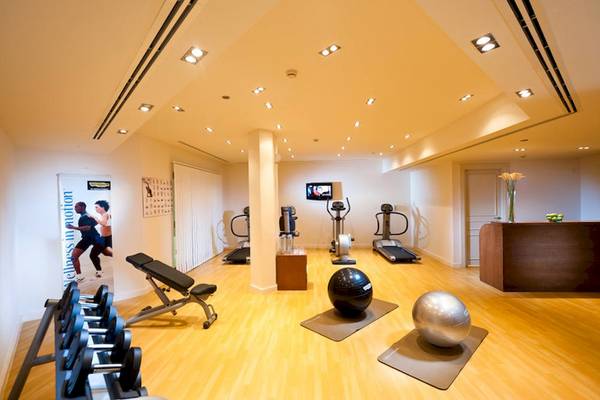Fitnesscenter im Sifawy Boutique Hotel mit Laufband, Gewichten und Trainingsposter.