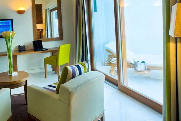 Sifawy Boutique Hotel Zimmer mit Fernseher, Schreibtisch und Gartenblick.