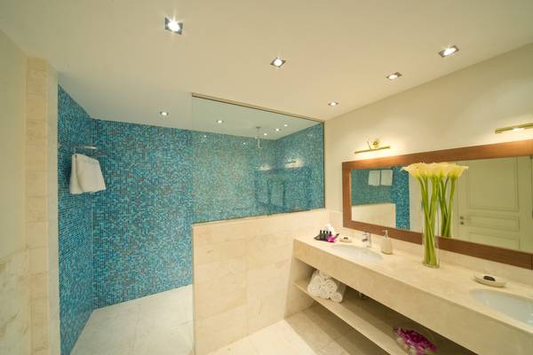 Badezimmer im Sifawy Boutique Hotel mit blauen Fliesen und Doppelwaschbecken.