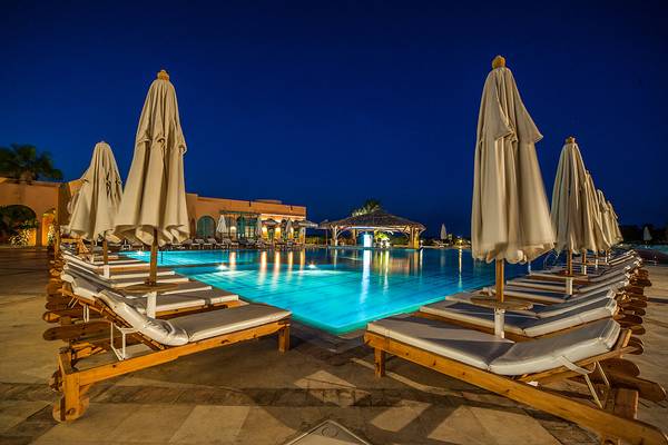 Badi am Pool des Chedi El Gouna bei Nacht mit Lounge-Stühlen und Sonnenschirmen