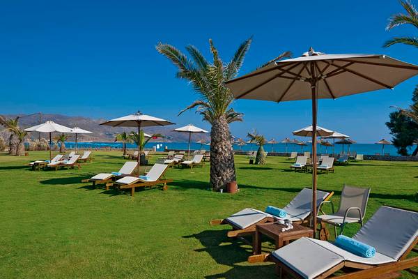 Terrasse des Giannoulis Cavo Spada Sports & Leisure Resorts mit Liegen und Sonnenschirmen.