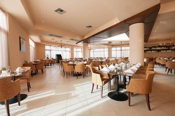 Innenansicht des Restaurants im Giannoulis Cavo Spada Sports & Leisure Resort mit vielen gedeckten Tischen und Stühlen.