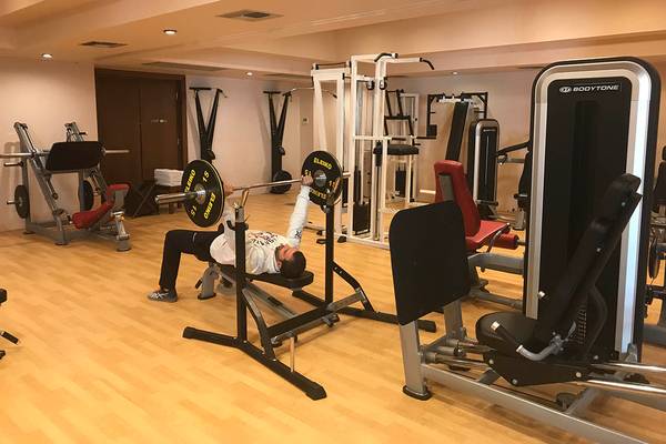 Ein Mann macht Liegestütze auf einer Bank im Fitnessstudio von Giannoulis Cavo Spada Sports & Leisure Resort.