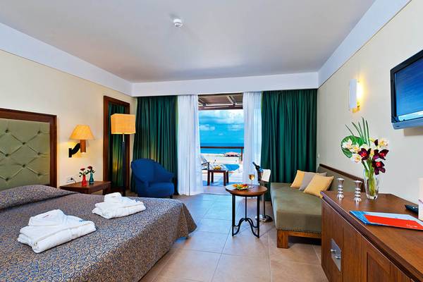 Hotelzimmer im Giannoulis Cavo Spada Sports & Leisure Resort mit Meerblick, Bett, Tisch, Fernseher und Balkon.