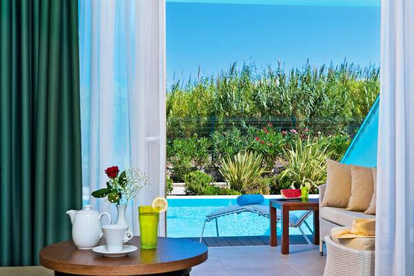 Innenansicht eines Zimmers im Giannoulis Cavo Spada Sports & Leisure Resort mit Blick auf den Pool.