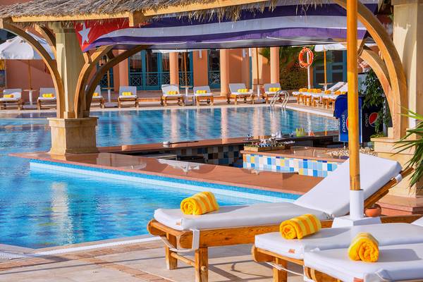 Poolbereich im Chedi El Gouna Hotel mit Loungestühlen und Sonnenschirmen.