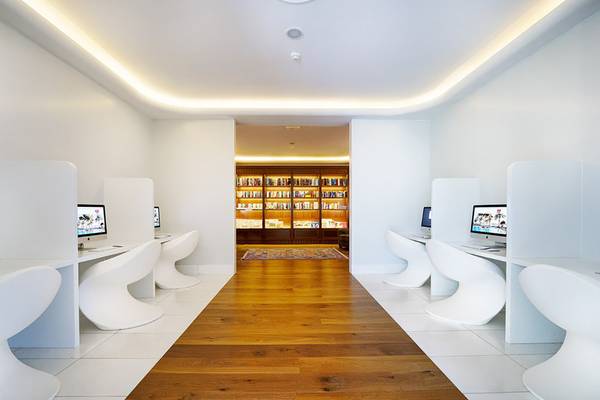 Weiße Bibliothek mit Büchern und ein Arbeitsbereich mit Computern im Bull Costa Canaria & Spa Hotel.