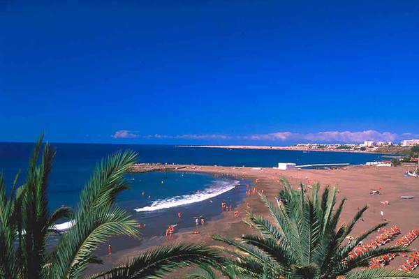 Strandansicht des Bull Costa Canaria & Spa Hotels mit vielen Gästen und Palmen
