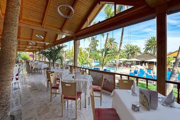 Innenansicht des Restaurants im Bull Costa Canaria & Spa Hotel mit Tischen und Stühlen, Blick auf den Swimmingpool.