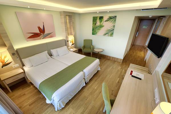 Doppelzimmer im Bull Costa Canaria & Spa Hotel mit zwei Betten, Schreibtisch und Fernseher.