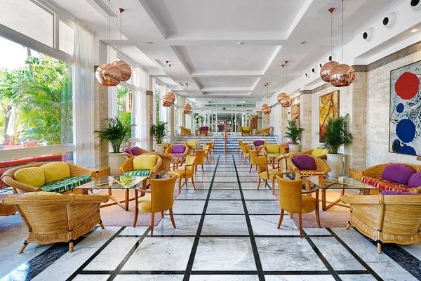 Innenansicht des Bull Costa Canaria & Spa Hotel-Lobbys mit farbenfrohen Möbeln und Pflanzen.
