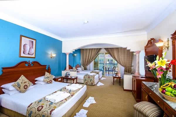 Zimmer im Titanic Palace Hotel mit zwei Betten, Dekor und Balkon.