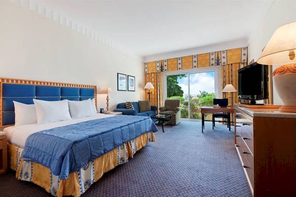 Hotelzimmer im Hilton Salalah Resort mit einem Bett, Sofa, Fernseher und Schreibtisch.