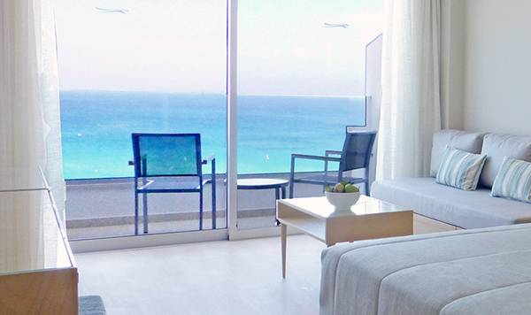 Zimmer mit Meerblick im Sunrise Beach Hotel in Zypern, mit Doppelbett, Sofa und Balkon.