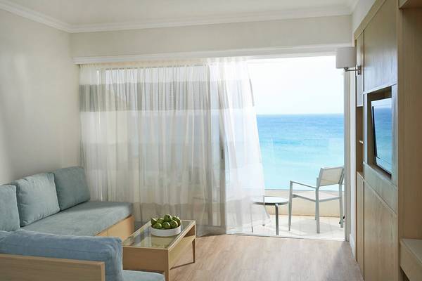 Wohnzimmer mit Meerblick im Sunrise Beach Hotel in Zypern, mit Couch, Tisch, Fernseher und Balkon
