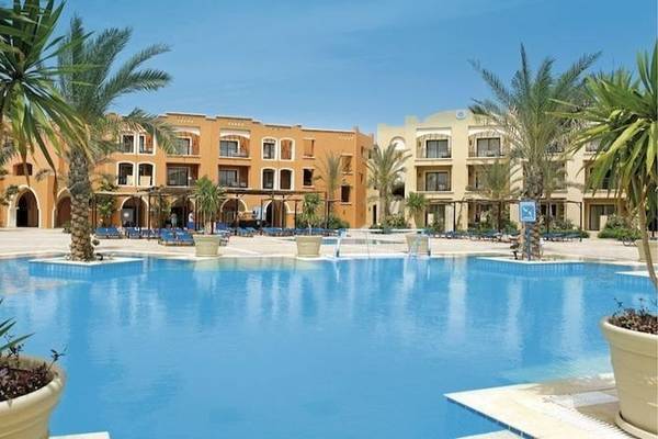 Außenbereich des JAZ Neo Dar El Madina Hotels mit Swimmingpool und Palmen