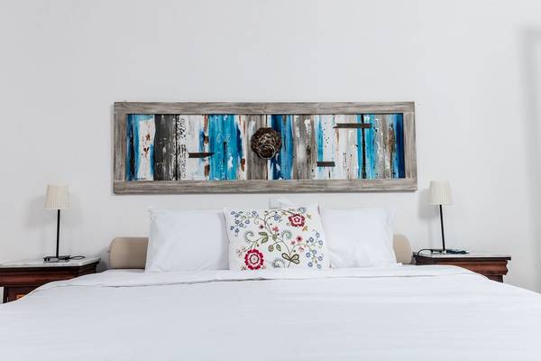 Schlafzimmer im Rhenia Mykonos Hotel mit einem großen Bett und einer Wandkunst.