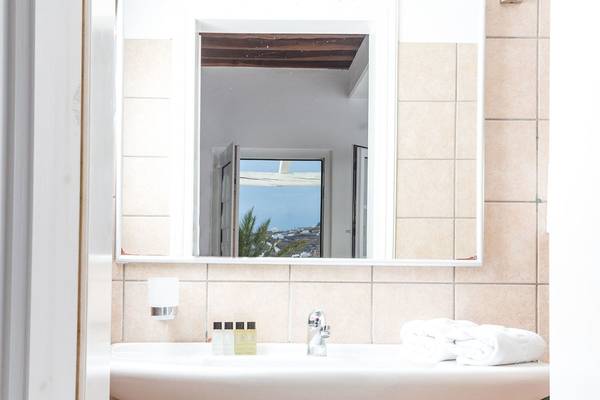 Badezimmer des Rhenia Mykonos Hotel mit Spiegel und Aussicht.