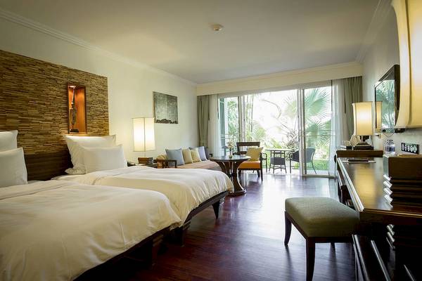 Doppelzimmer im Robinson Khao Lak Hotel mit zwei Betten, Wohnzimmerbereich und Terrasse.