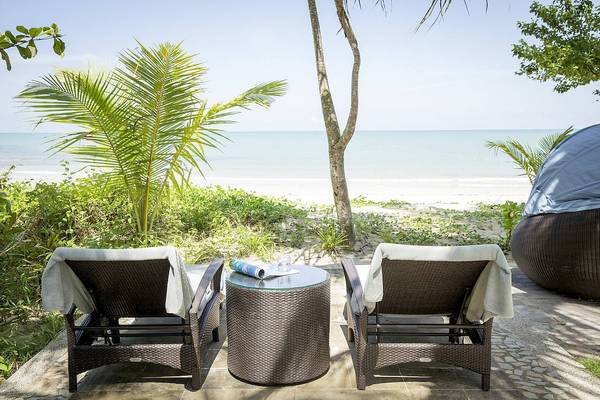 Zwei Korbsonnenliegen stehen auf einer Terrasse am Strand von Robinson Khao Lak.