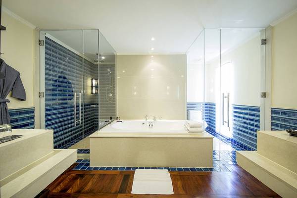 Badezimmer im Robinson Khao Lak Hotel mit Badewanne und blauen Fliesen.