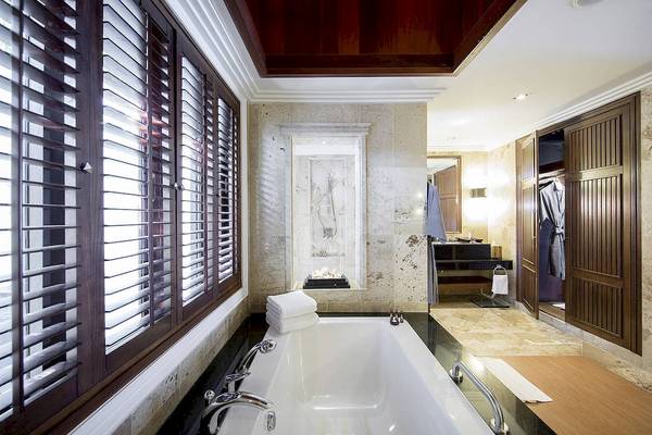 Badezimmer im Robinson Khao Lak Hotel mit Badewanne, Dusche und Holzelementen.