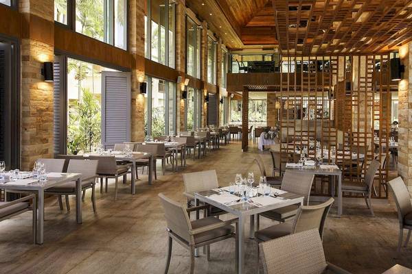 Innenansicht des Restaurants im Robinson Khao Lak Hotel mit runden Tischen und Stühlen.