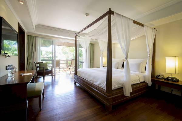 Schlafzimmer im Robinson Khao Lak Hotel mit einem Himmelbett, einem Schreibtisch und einem Balkon.