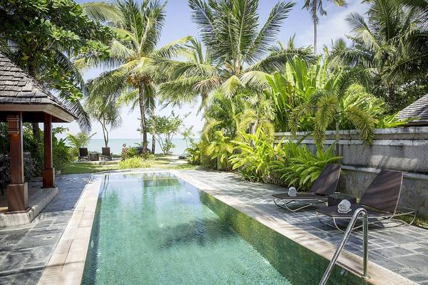 Außenpool im Robinson Khao Lak Hotel, umgeben von Palmen und Pflanzen.