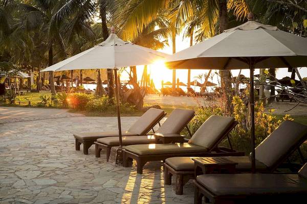 Lounge-Stühle unter Sonnenschirmen im Robinson Khao Lak Hotel.