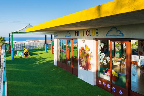 Außenansicht des Mini Clubs im Grand Hotel Holiday Resort mit farbenfrohen Wandmalereien und Spielgeräten im Freien.