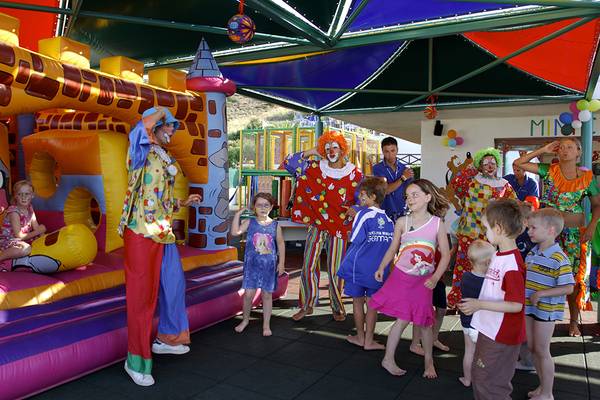 Kinder und Clowns spielen auf einer Hüpfburg im Freien im Grand Hotel Holiday Resort