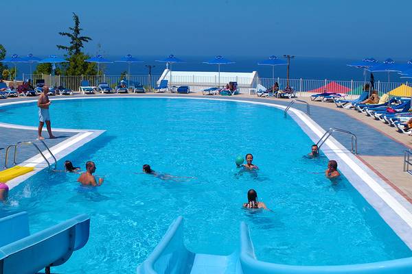 Schwimmbeckenbereich des Grand Hotel Holiday Resort mit Gästen, die schwimmen und entspannen.