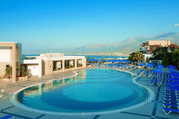 Außenpool des Grand Hotel Holiday Resort mit blauen Sonnenschirmen und Liegestühlen