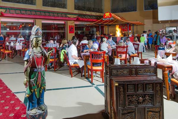 Innenbereich des Titanic Palace Restaurants mit Gästen an Tischen und einer Statue.