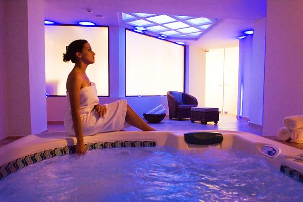 Eine Frau sitzt im Jacuzzi des Grand Hotel Holiday Resort und genießt die Atmosphäre.