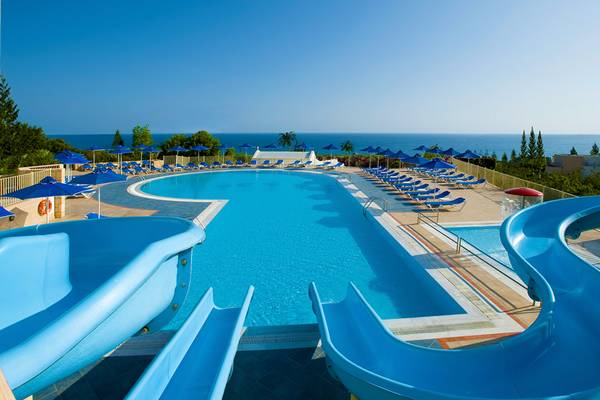 Außenpool mit Wasserrutschen und Sonnenliegen im Grand Hotel Holiday Resort