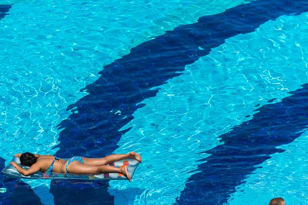 Eine Frau liegt entspannt auf einer Luftmatratze im Pool des Grand Hotel Holiday Resort.