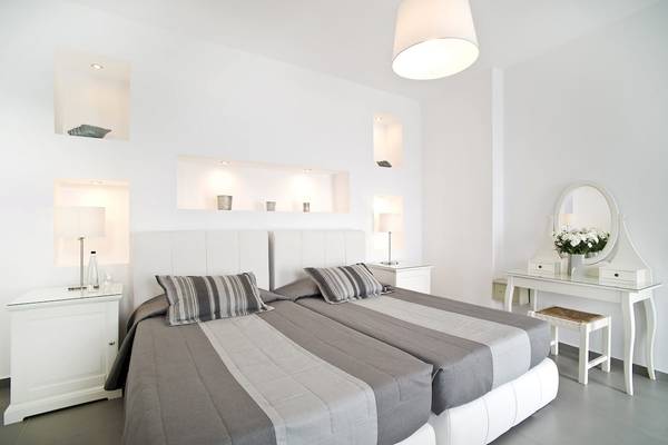 Doppelbett-Zimmer im Agali Houses Hotel mit weißen Möbeln und grauen Laken.