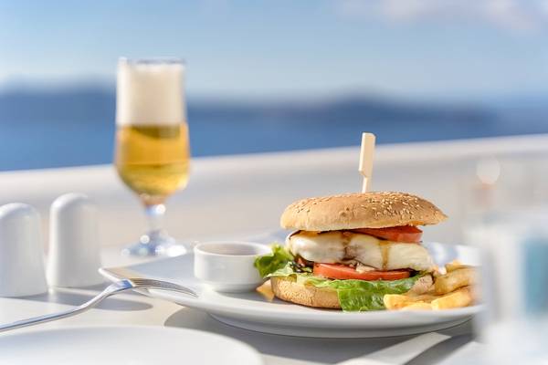 Gerichteter Teller mit Burger, Pommes und Getränk auf der Terrasse der Agali Houses.