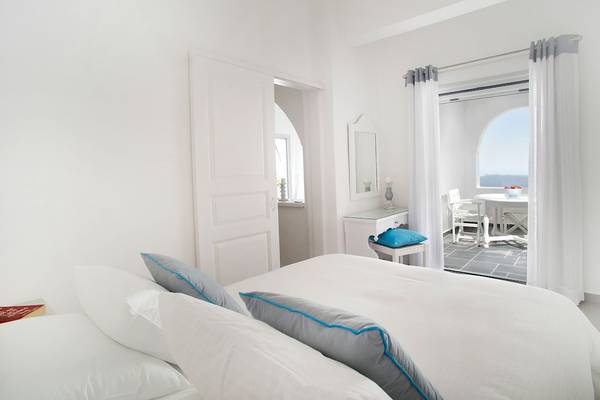 Ein modernes, helles Zimmer im Agali Houses Hotel mit Blick auf die Außenterrasse.