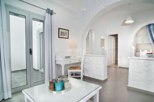 Weißes Wohnzimmer von Agali Houses mit einem Schreibtisch, Stühlen und einer offenen Tür.
