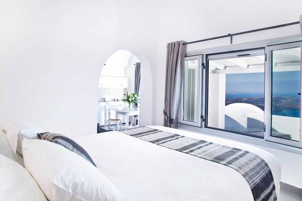Schlafzimmer mit Aussicht auf das Meer im Agali Houses Hotel.
